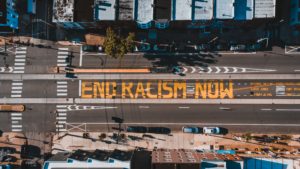 birds eye view of a street painted with "END RACISM" in yellow